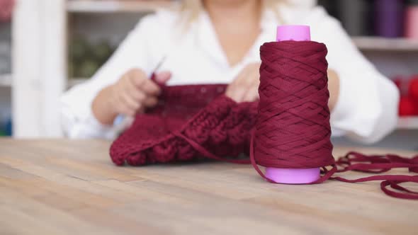 Woman with Crochet Hook Crocheting with Red Yarn at Home alt