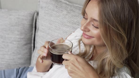 Woman Relaxing On Sofa With Coffee