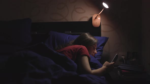 Young Girl Using Her Phone at Night