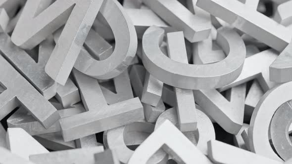 Full Frame Closeup Looped Slowly Rotating Background of Silver Metal Letters with Selective Focus alt