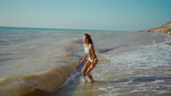Happy Carefree Lauhging Slender Woman with Beautiful Fitbody at Seashore with Waves After Storm Girl alt