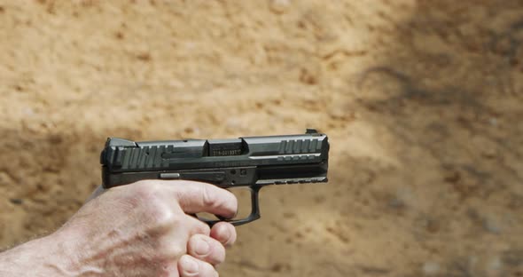 Pistol shooting bullets in slow motion footage. Hand guns in firing range alt