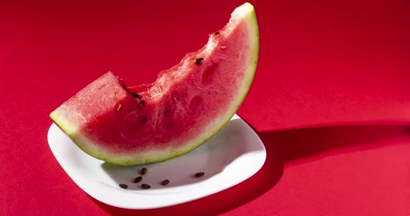 Slice of watermelon bite on red background. Stop motion animation