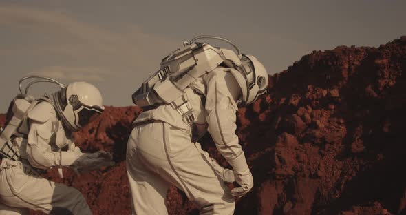 Astronaut Examining Rock on Mars alt