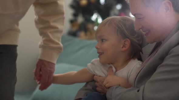 Mature Active Woman with a Short Haircut and in a Business Suit Hugs a Happy Little Blondie Girl alt