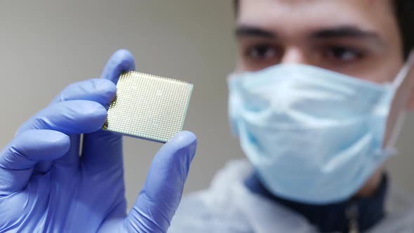 Young Engineer Holds in Hand CPU Processor