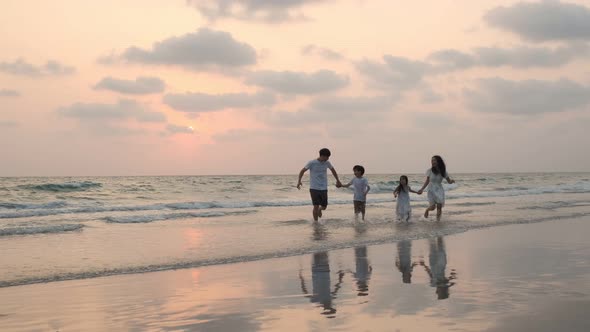 Asian Family running and jumping together at beach with kids happy vacation travel beach concept