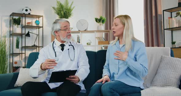 Doctor Listening Upset Blond Woman which Telling Health Complaints During His Home Visit alt