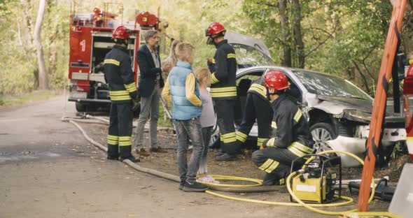 Family Talking with Firemen After Road Accident alt