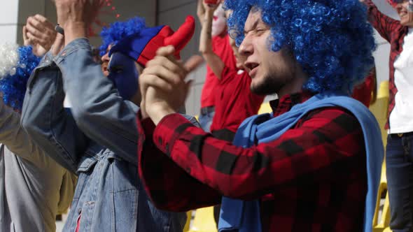 Agitated Fans Clapping Hands and Shouting Slogans at Stadium alt