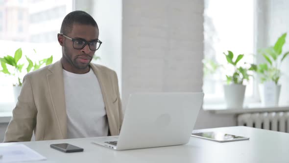 African Man Closing Laptop Standing Up Going Away alt
