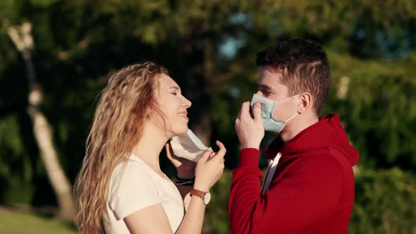Young Family Couple in Love Medical Protective Masks in City Sunset alt