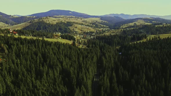 Countryside behind the forest in the mountains. Aerial view. Slow motion