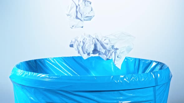 Super Slow Motion Shot of Crumpled Papers Falling Into Trash Can at 1000Fps alt