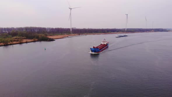 Aerial View Over Oude Maas On Overcast Day With Still Wind Turbines On Rivers Edge And Cargo Ships A alt