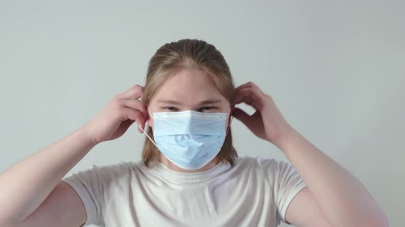 Portrait of Young Caucasian Young Man Putting on Face Medical Mask