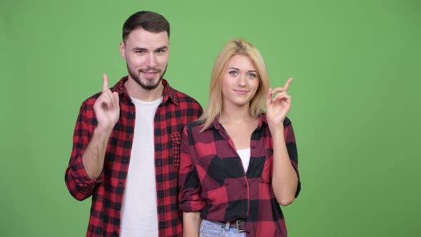 Young Couple Pointing Finger Up Together