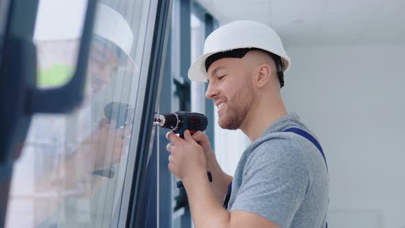 Window Installer in a Helmet and a Screwdriver Installs Windows alt