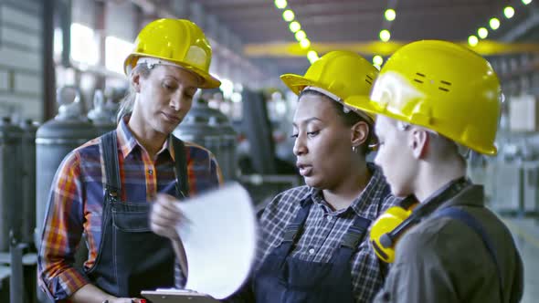 African Factory Engineer Speaking with Employees alt