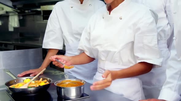 Team of chefs tasting food in the kitchen alt