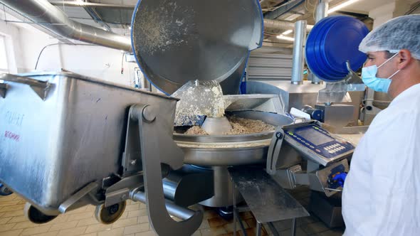 Pieces of Alimentary Material are Getting Put Into the Factory Machine alt