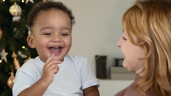 A Little Boy Laughs Near the Xmas Tree Closeup alt