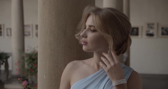 young woman in a festive outfit demonstrates precious jewelry alt