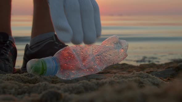 Man Volunteer Collects Plastic on the Beach Closeup alt