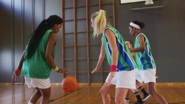 Diverse female basketball team playing match, dribbling and shooting ball alt