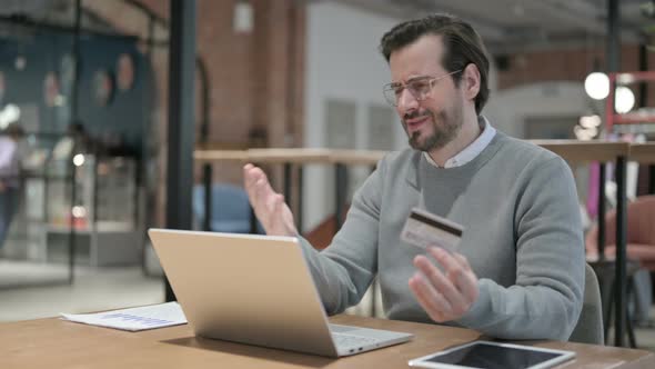Young Man Making Online Payment Failure on Laptop in Office alt