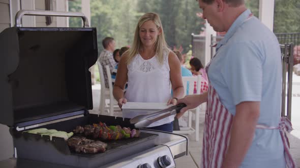 Serving food from grill at backyard barbeque