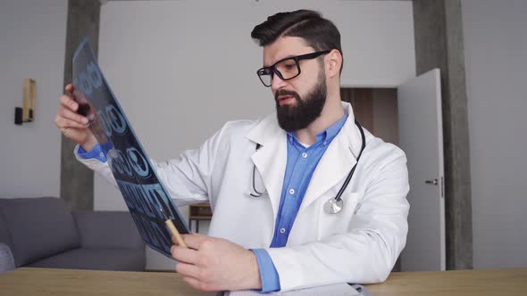 Male Doctor Talking to Patient Showing Lungs Mri Scan Looking at Camera alt