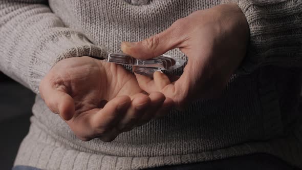 Medical capsules squeezes out of the blister. Men's hands close-up. Lecithin. alt