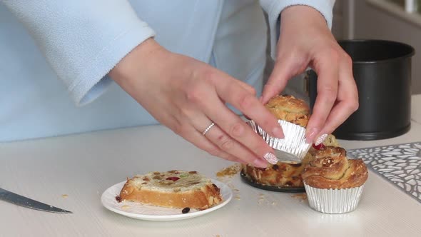 A Woman Demonstrates A Cooked Cruffin With Raisins And Candied Fruit. Medium Plan. alt
