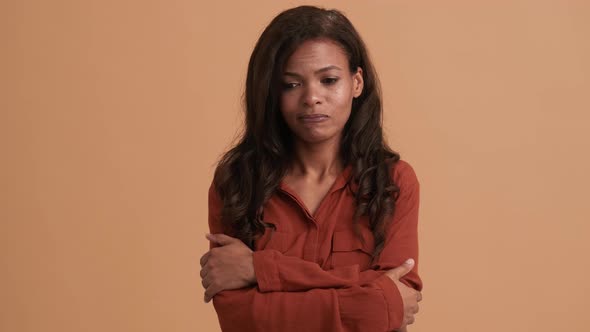 A disappointed brunette african american woman holding hands alt