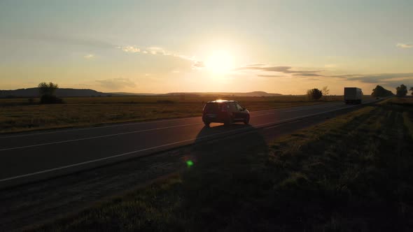 Aerial shot: flying along road with driving vehicles, trucks and cars alt