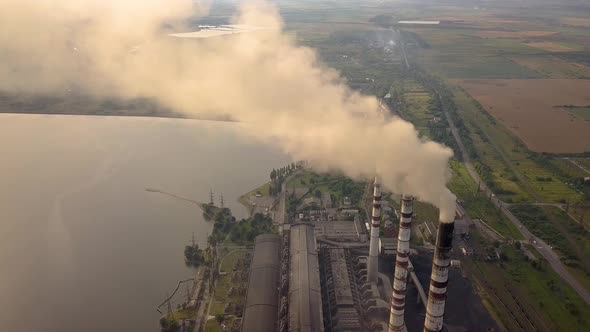 Aerial view of high chimney pipes with grey smoke from coal power plant. Production of electricity alt