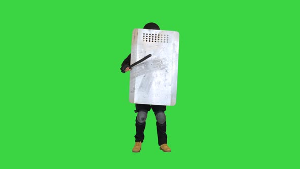 Special Unit Policeman Covering with a Shield and Holding a Baton on a Green Screen Chroma Key alt