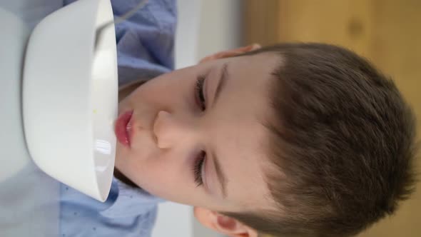 Small Hungry Boy Eating Tasting Sweet Corn Flakes with Milk at Morning alt