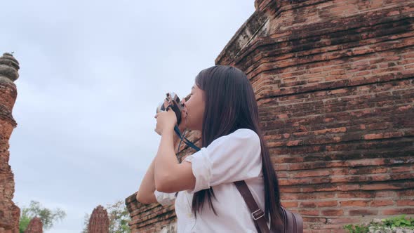 Asian woman using camera for take a picture while spending holiday trip at Ayutthaya, Thailand.