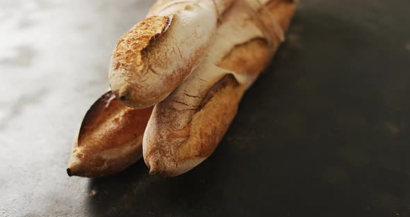 Video of baguettes tied with lace on a black surface alt
