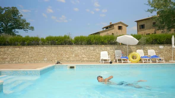 A Boy Jumping Into the Pool for a Swim alt