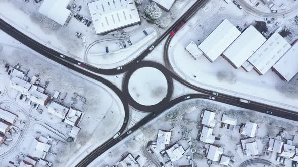 Aerial view of traffic on a roundabout with snow on the side of the road