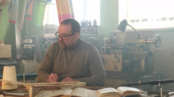 A Man Works in a Woodworking Workshop alt