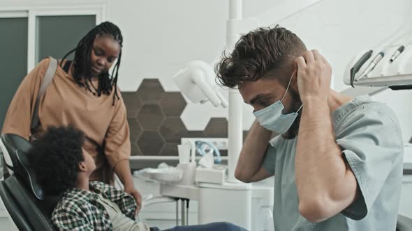 Dentist Putting on Mask and Gloves alt