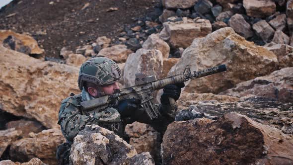 A Bearded Soldier on the Mountains in a Tactical Military Uniform with a Helmet on His Head with a alt