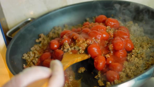 Mix the Ingredients for the Chorizo and the Preserved Tomatoes with a Wooden Spoon alt