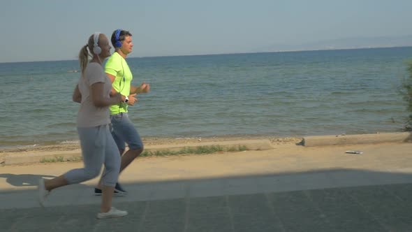 People in Headphones Jogging along the Esplanade alt
