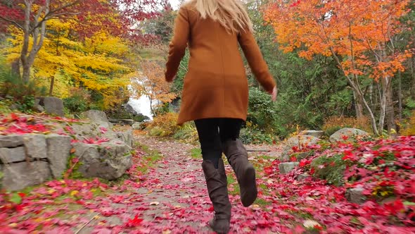 Young Female in the Fall Running on Path with Colorful Leaves