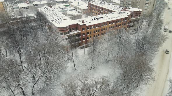An Old House with a Destroyed Roof Covered with Snow After a Blizzard alt